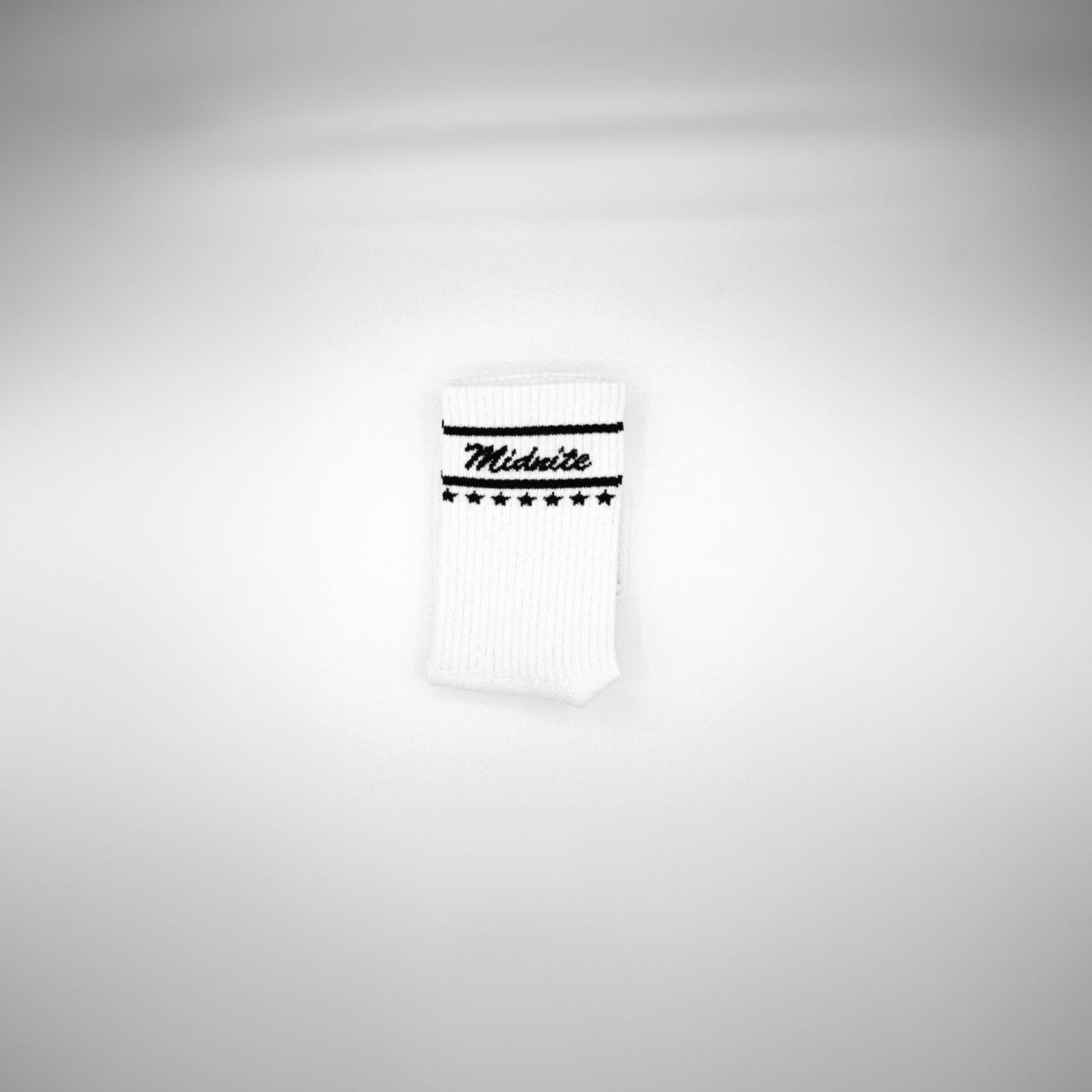 Midnite Club white streetwear socks – ribbed athletic crew socks with black cursive logo and star detailing, inspired by retro motorsport and underground fashion.